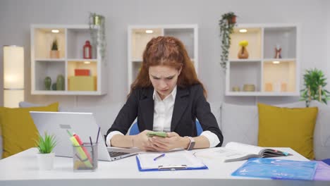 Home-office-worker-woman-gets-frustrated-while-looking-at-phone.